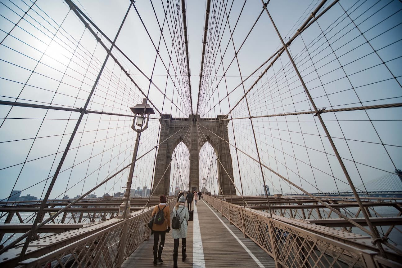 The pedestrian walkway on the Brooklyn Bridge with its iconic cables and arches.