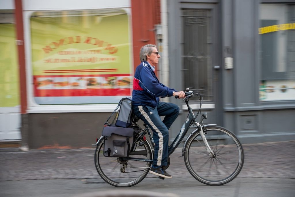 Cyclist passing colorful shopfronts in Bruges
