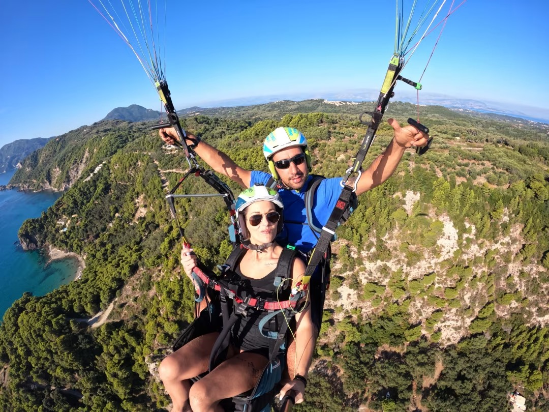 Paragliding over green cliffs and turquoise sea in Corfu